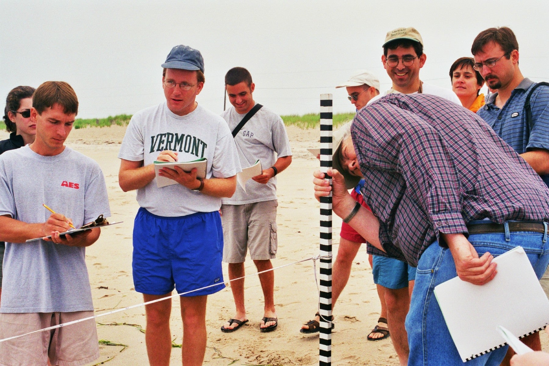 Group of people from 2000 standing around and measuring objects