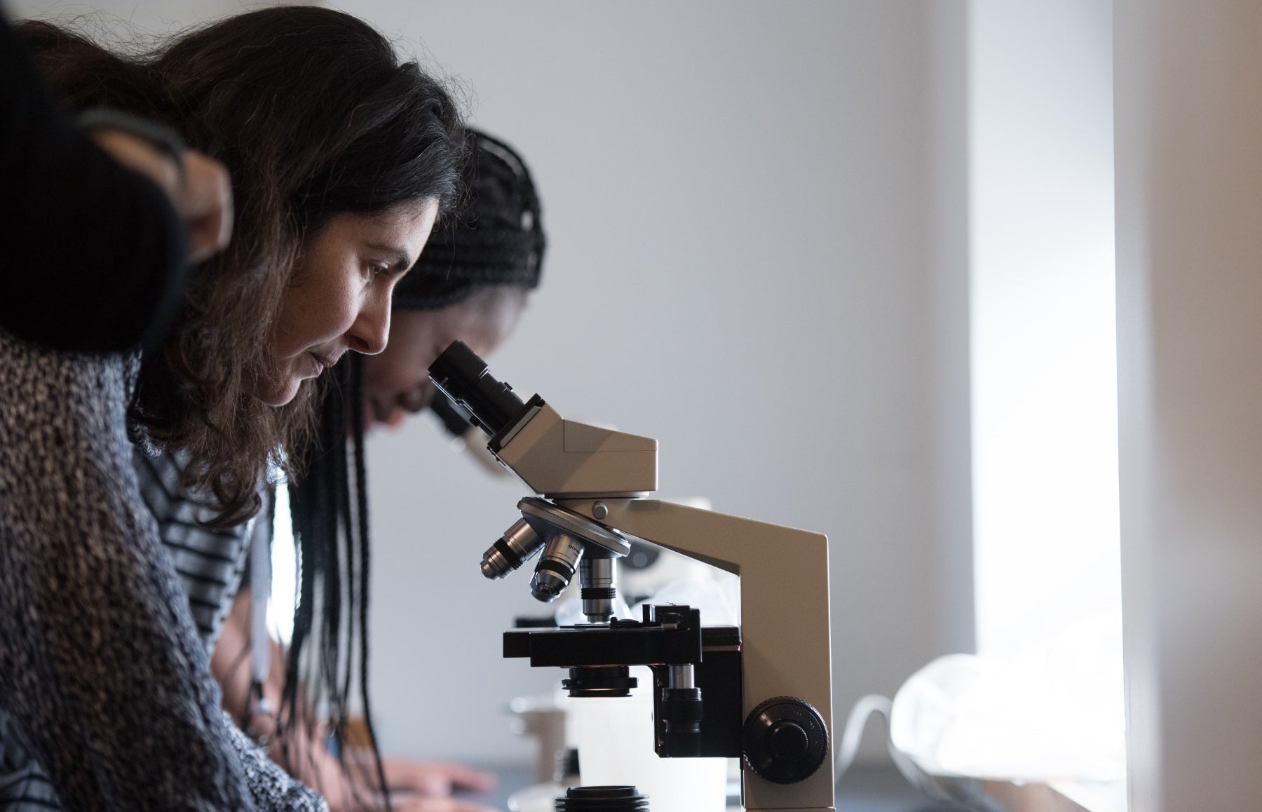 two women looking into microscopes